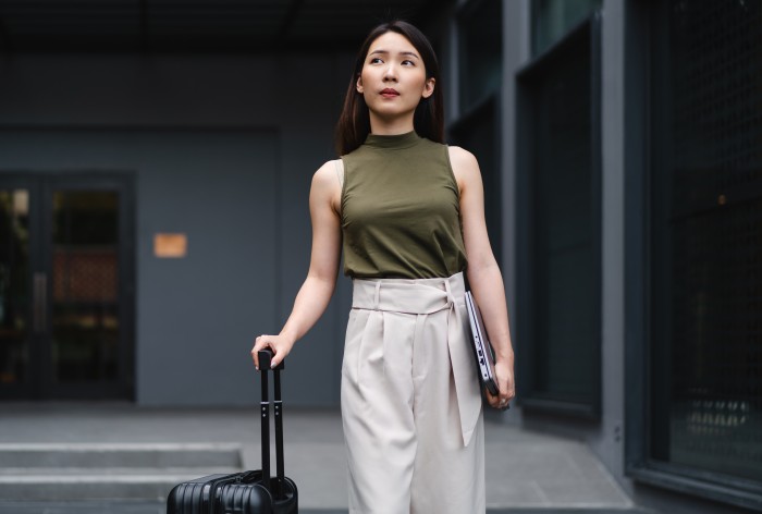 Business traveler holding suitcase looking into distance
