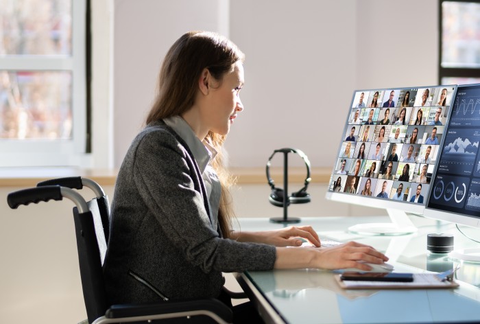 Business women in a meeting while looking at travel on a desktop in an office
